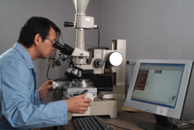 Richter Precision engineer looks through a microscope to ensure quality